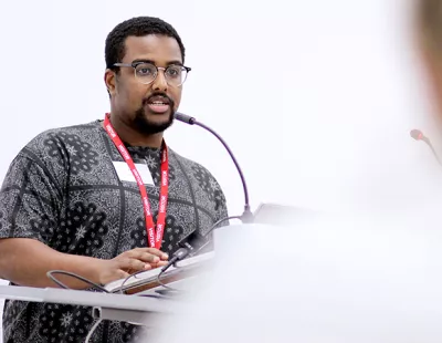 Young British Asian man speaking at a lectern