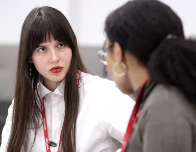 Two young women talking in an office