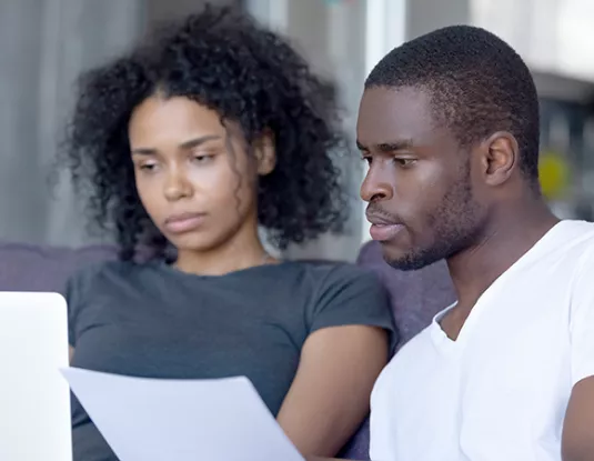 Black couple reading from a sheet of paper