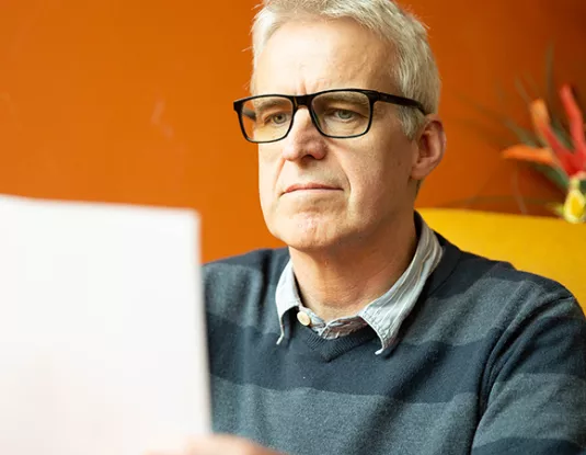 White man with glasses at a laptop