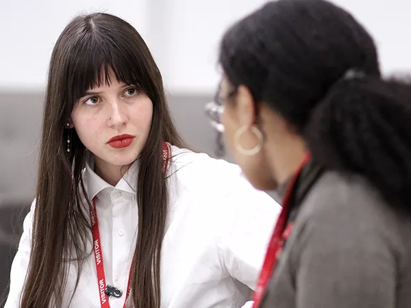 Two young women talking in an office